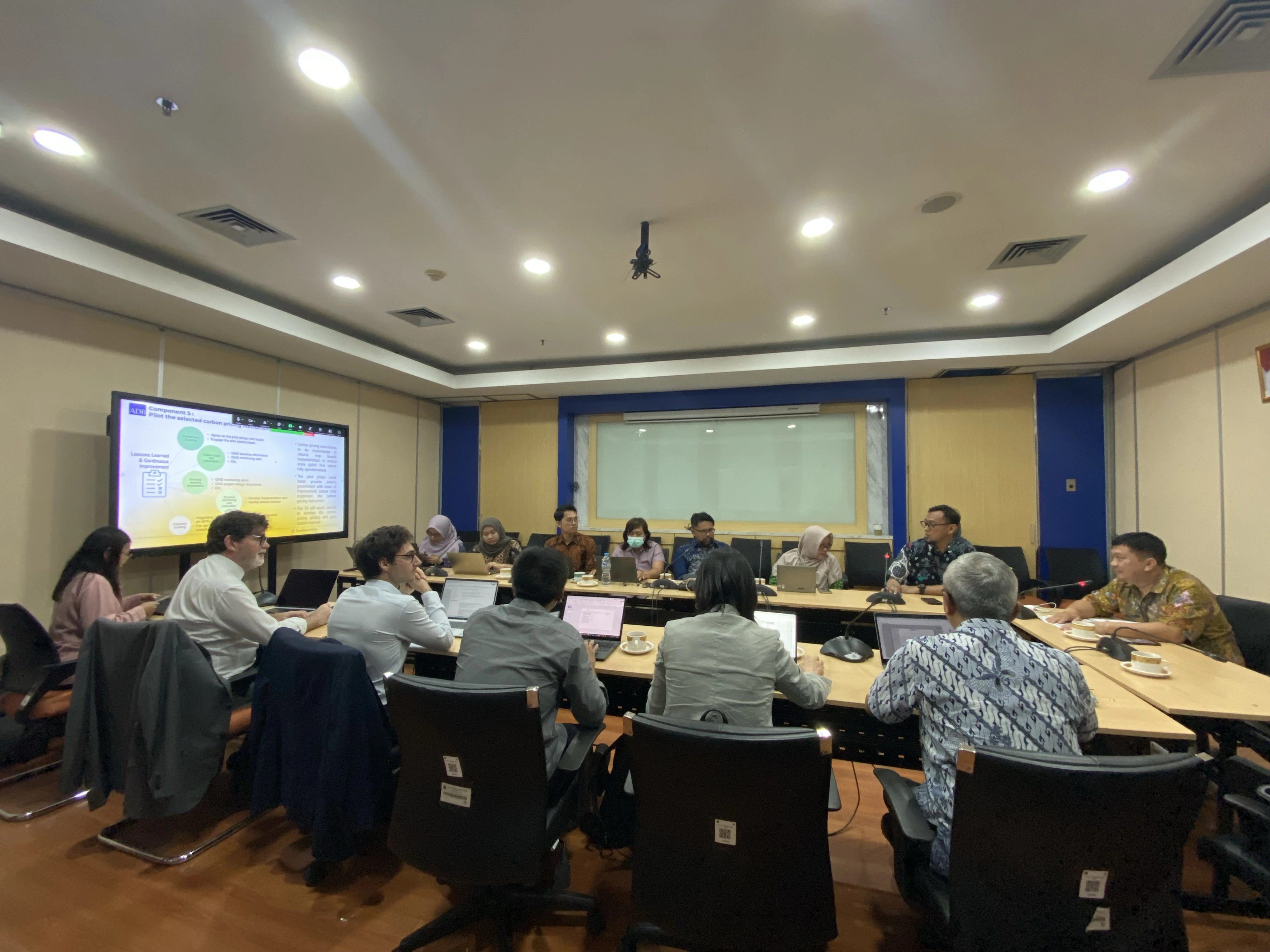 plusieurs personnes en réunion autour d'une table à Djakarta