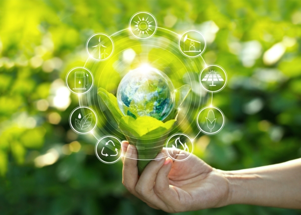 Main tenant la Terre entourée de pictogrammes d'énergies renouvelables, illustrant les dynamiques territoriales de production d’énergie durable