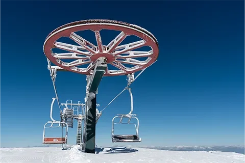 Visuel d'une remontée mécanique avec des traces de gel et un ciel nuageux dans le fond
